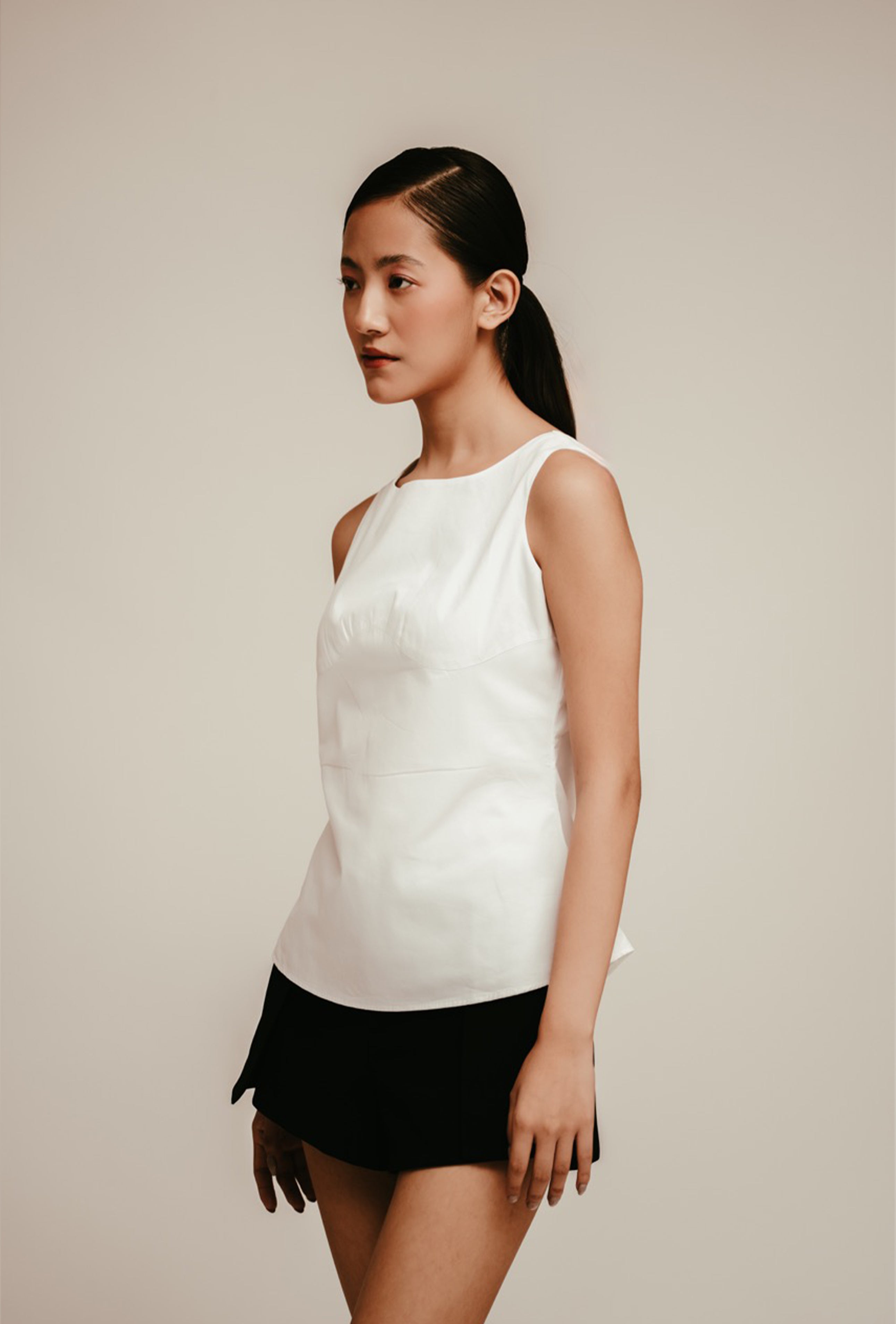 White Top Luxury women’s white sleeveless peplum top styled with black mini skirt – All Hearts No Spades quiet luxury minimalist clothing