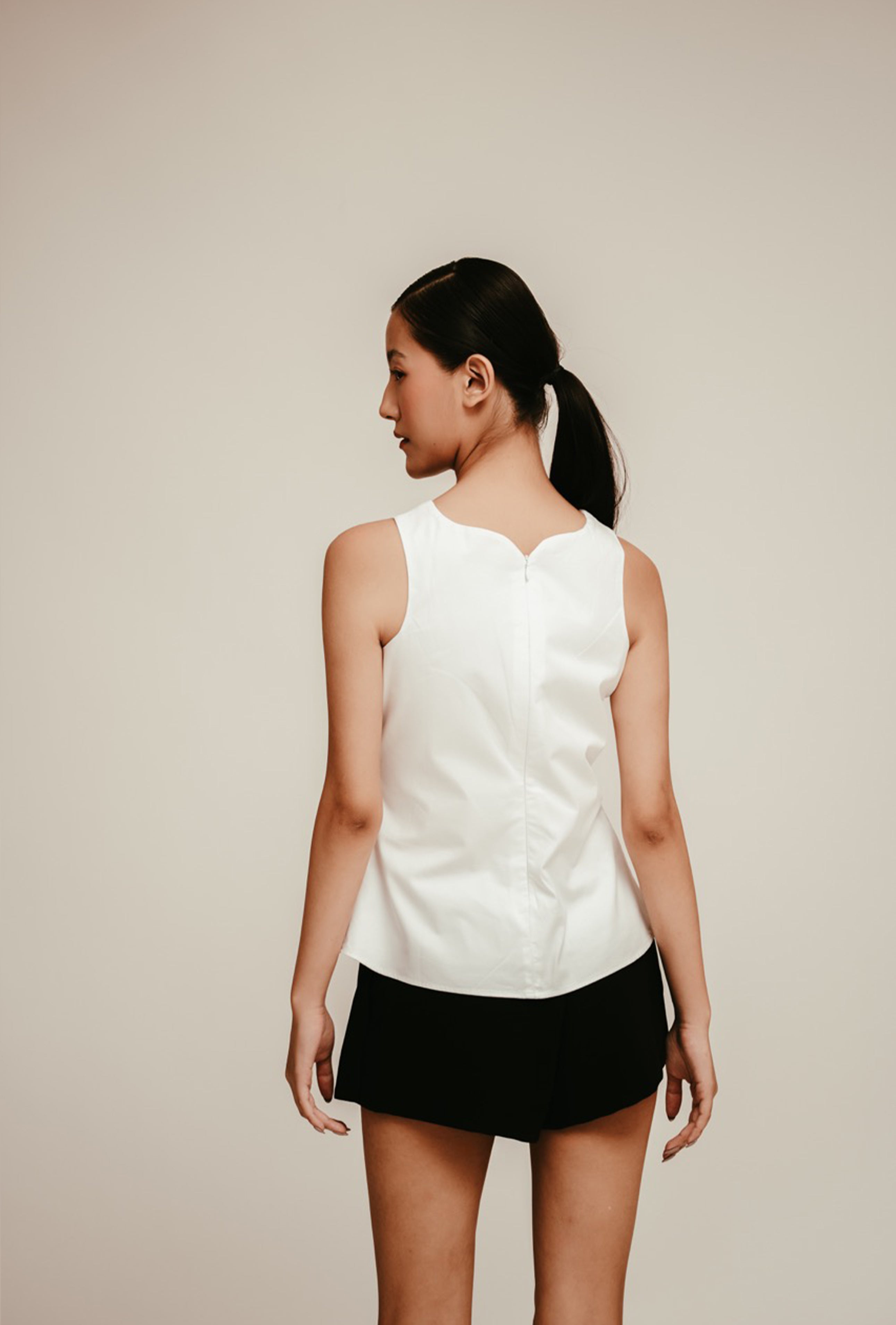 Luxury women’s white sleeveless peplum top styled with black mini skirt – All Hearts No Spades quiet luxury minimalist clothing
