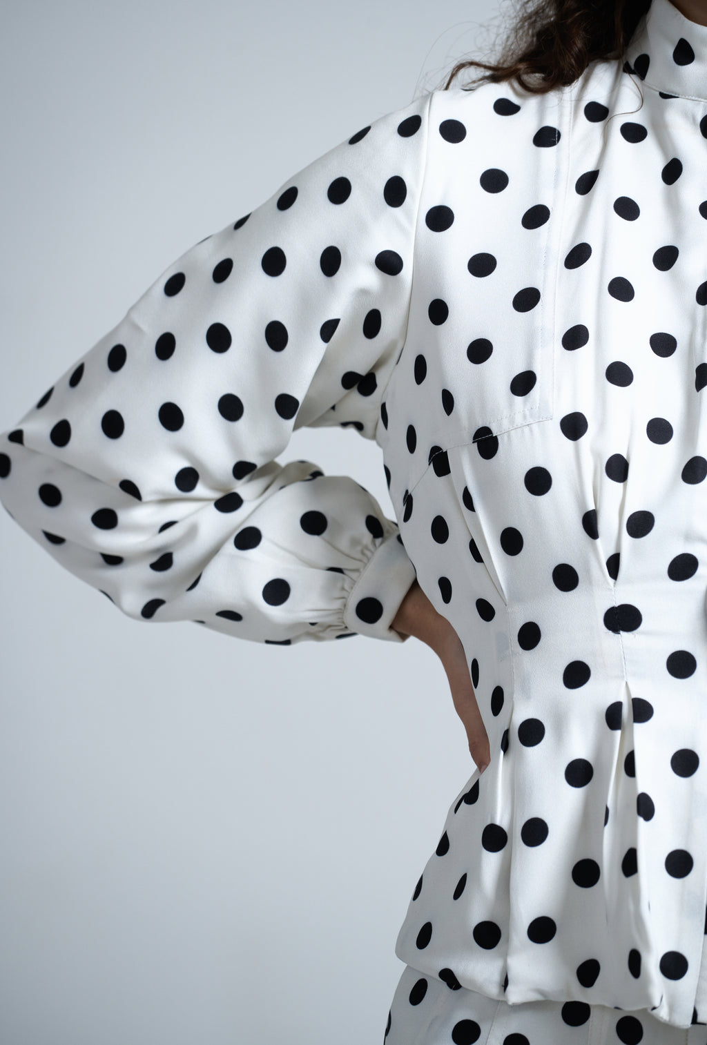 White outfit with black polka dots on a plain background